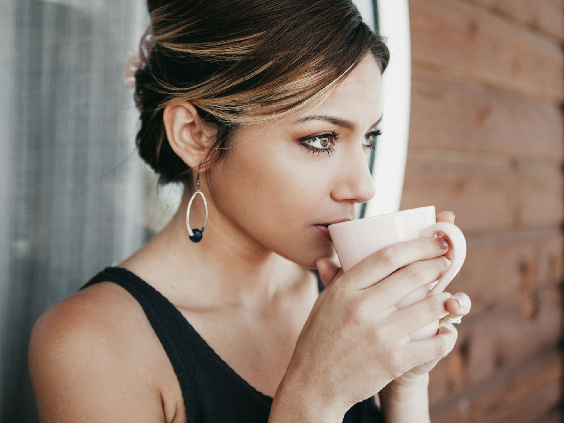 Woman in her 40s drinking coffee and reflecting on her health journey